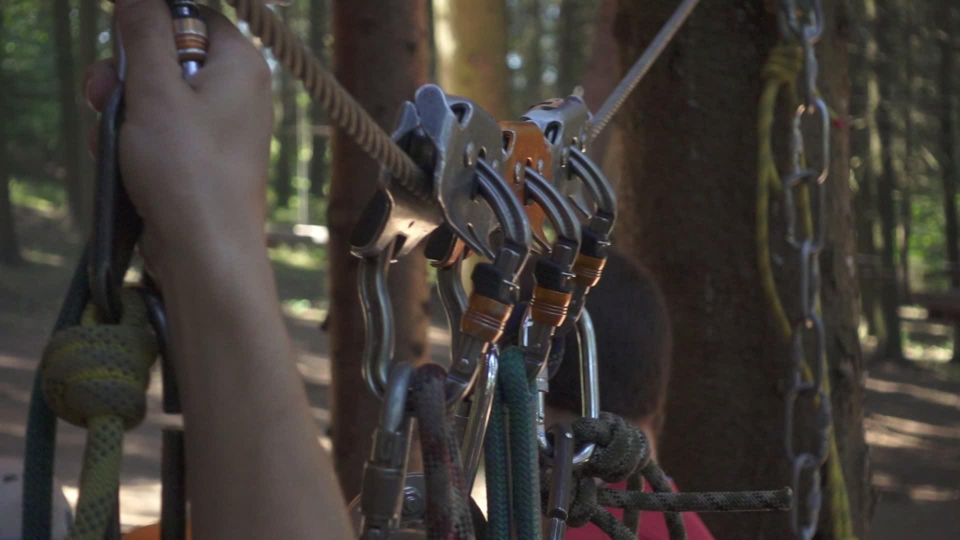 在冒险公园的极端攀爬树上团建男子手里拿着一根木绳视频的预览图