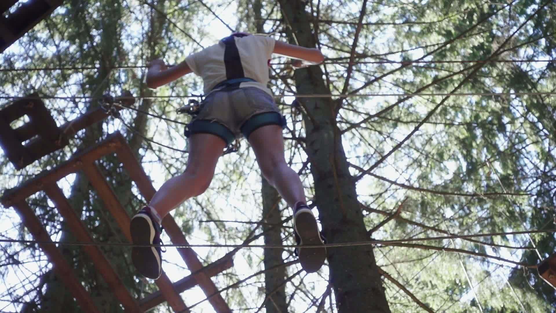 女青年在极端公园使用保护设备爬绳索视频的预览图
