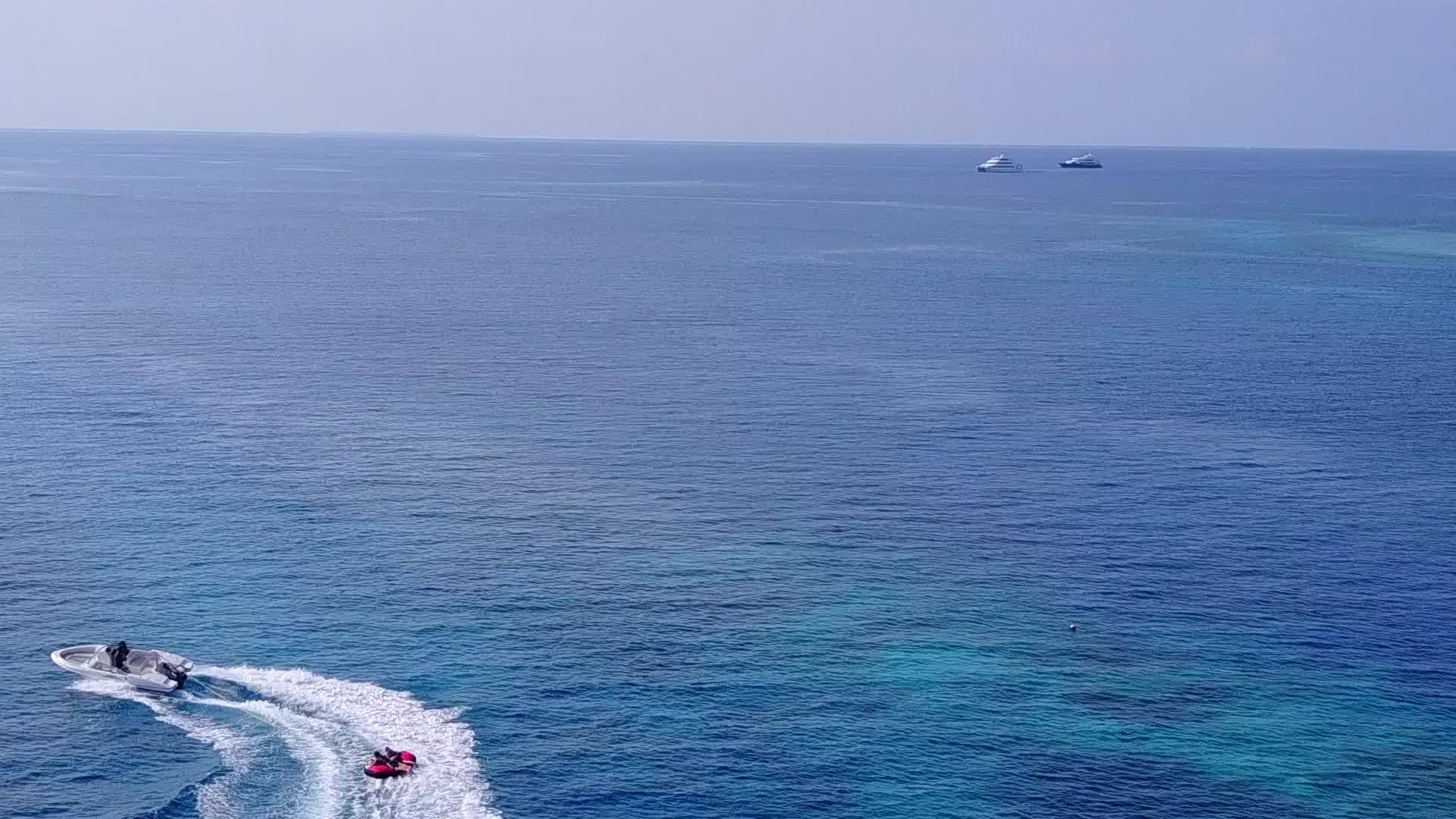 以白沙底浅海为背景背景观看无人驾驶海滩生活方式视频的预览图