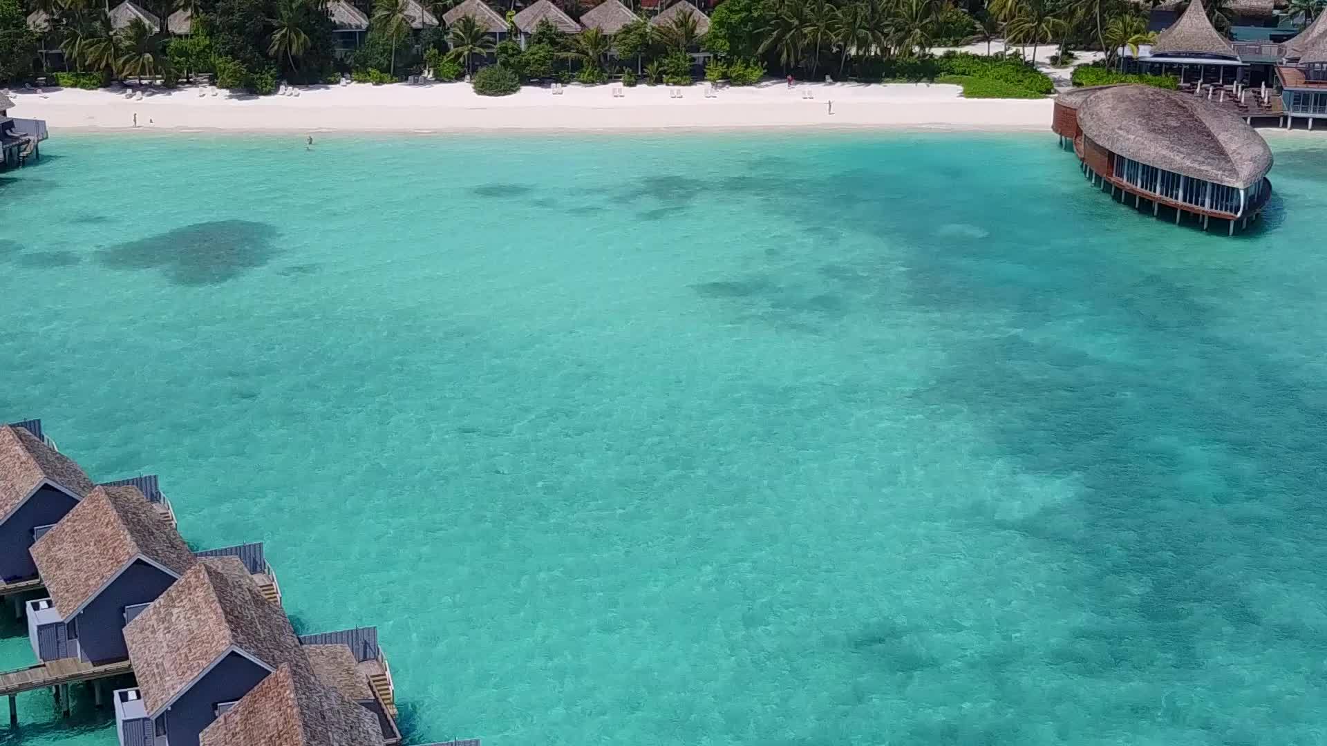 在清澈的海洋和白色的沙沙背景下美丽的海岸海滩时间在空中视频的预览图
