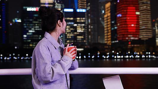 轮船上喝咖啡看夜景的女青年视频的预览图