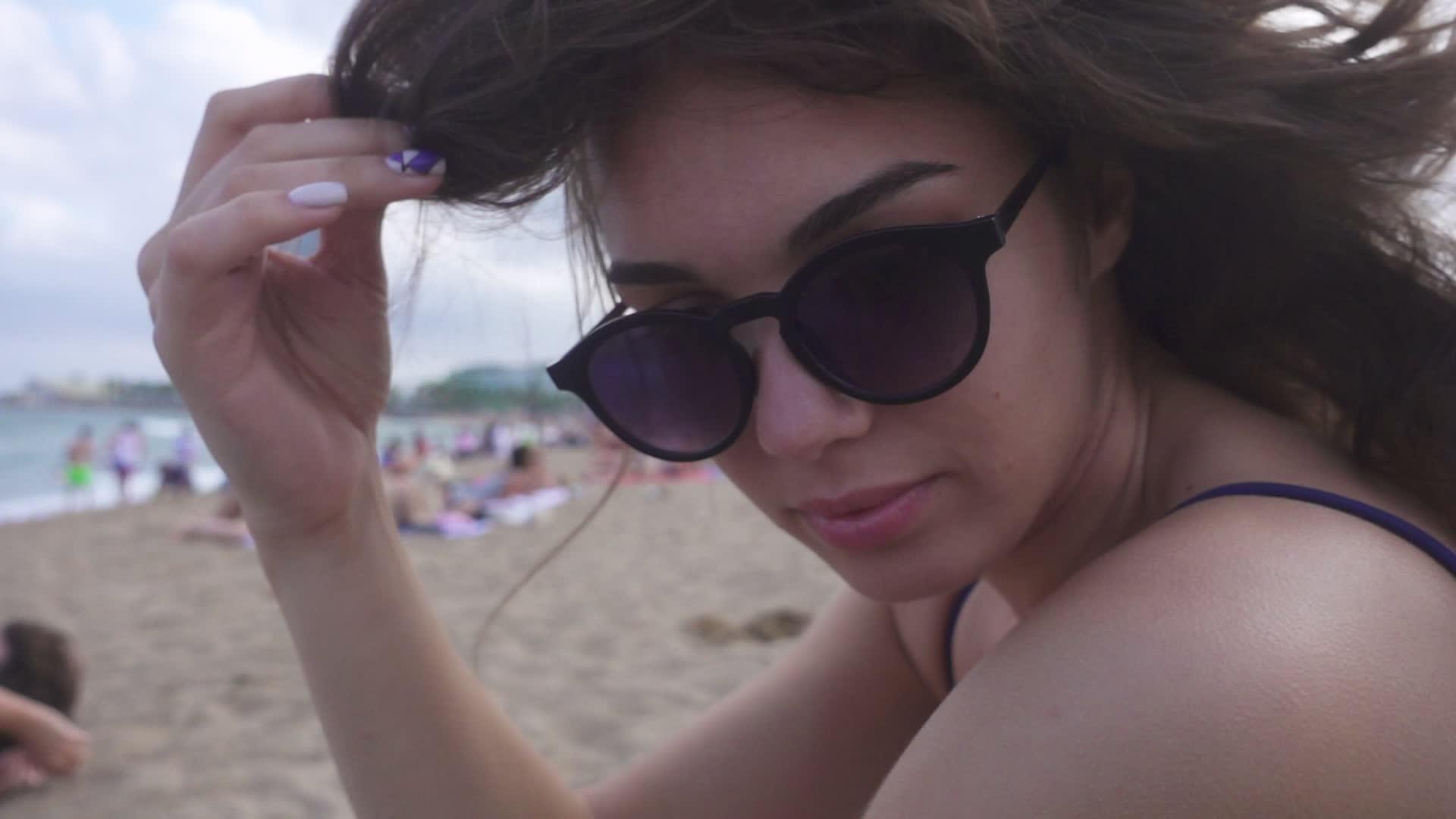 美丽的女孩坐在海滩上视频的预览图