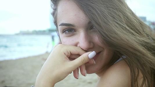 坐在沙滩上的美丽女孩视频的预览图