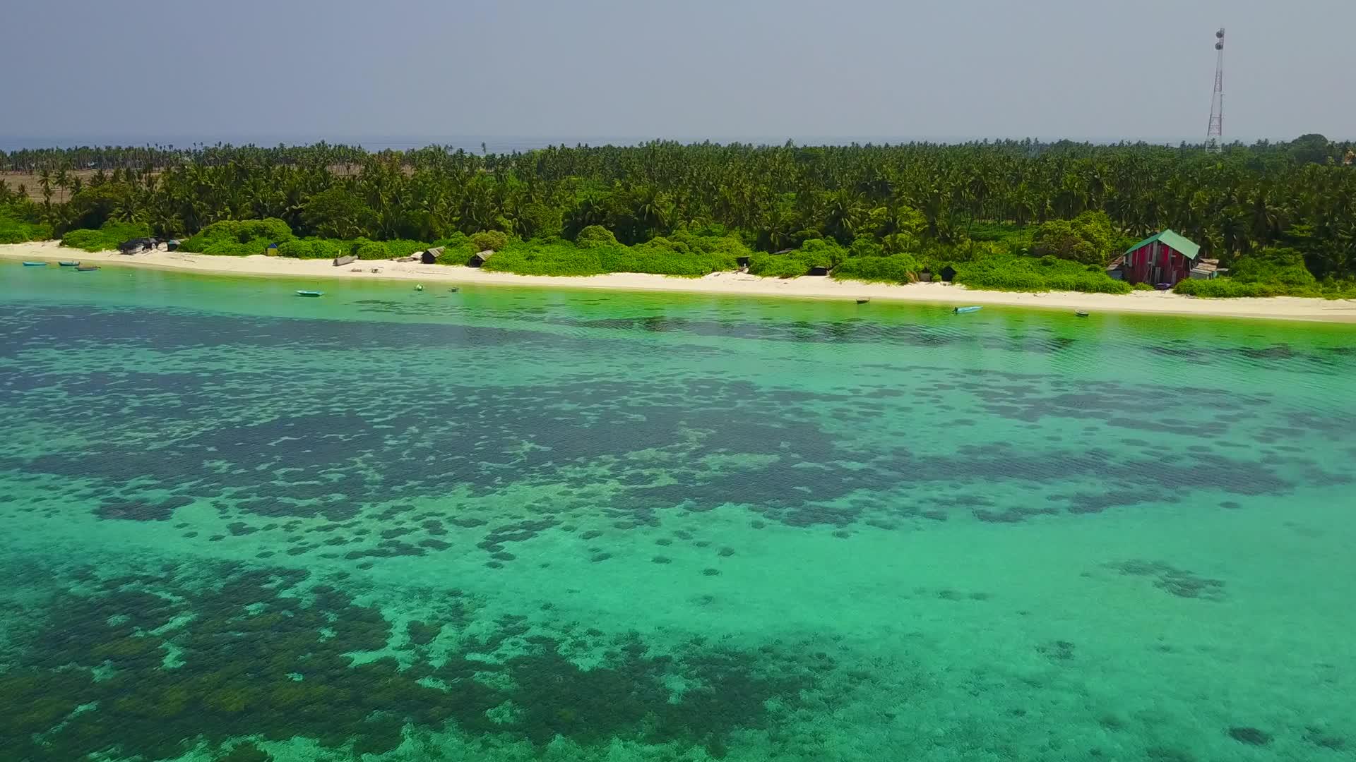 在蓝色泻湖和白沙的背景下美丽的海岸海滩生活方式的无人机全景视频的预览图