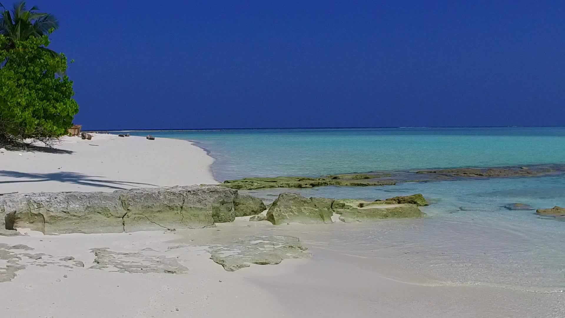 在透明的环礁湖和白色海滩的背景下缓慢的环礁海滩假视频的预览图