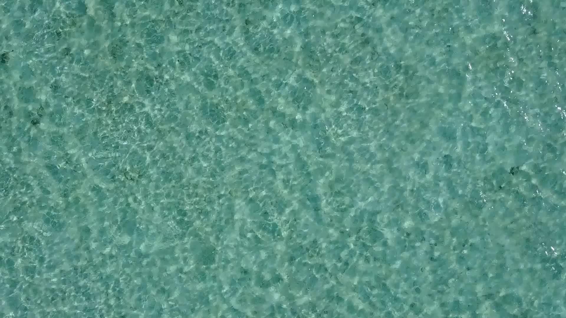 打破天堂岛海滩的空中无人驾驶蓝色海平面以白沙为背景视频的预览图