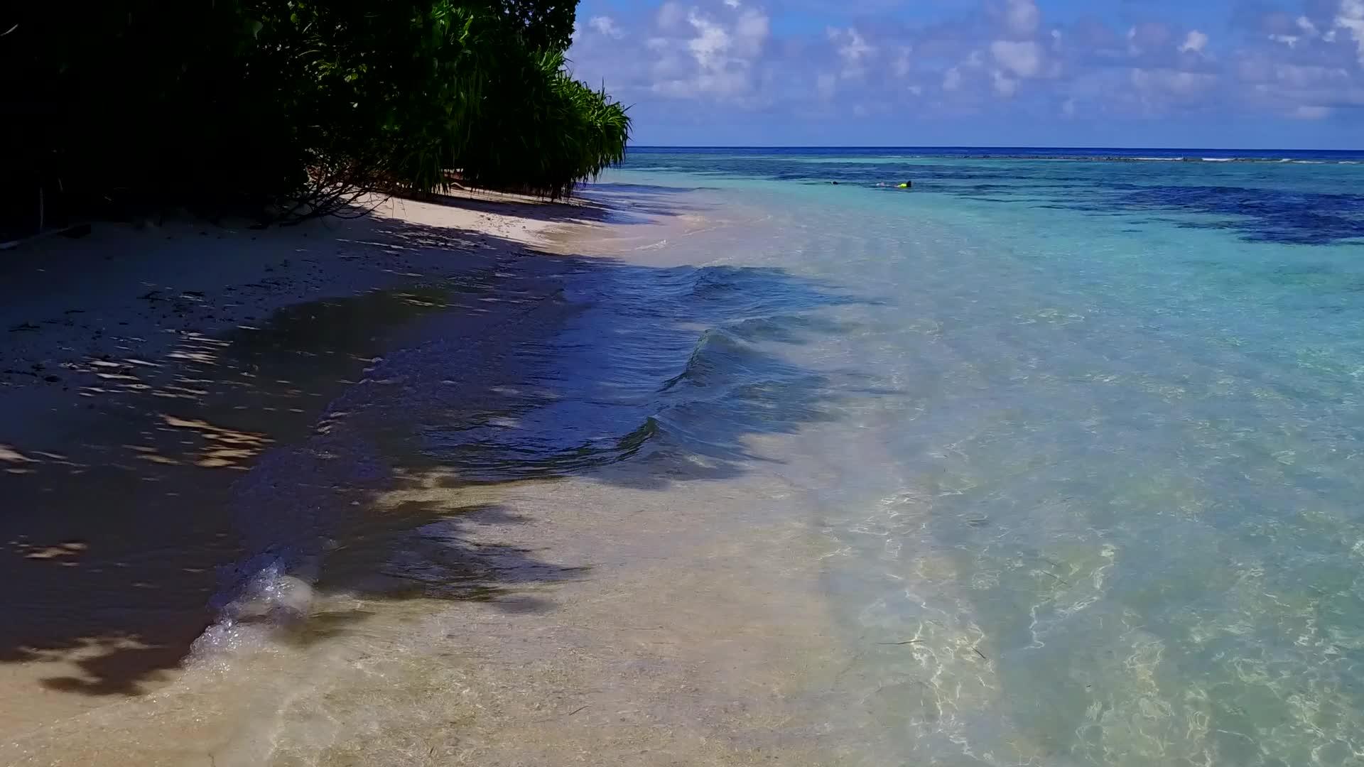 宁静的海滩以浅水和白色白色沙滩为特征视频的预览图