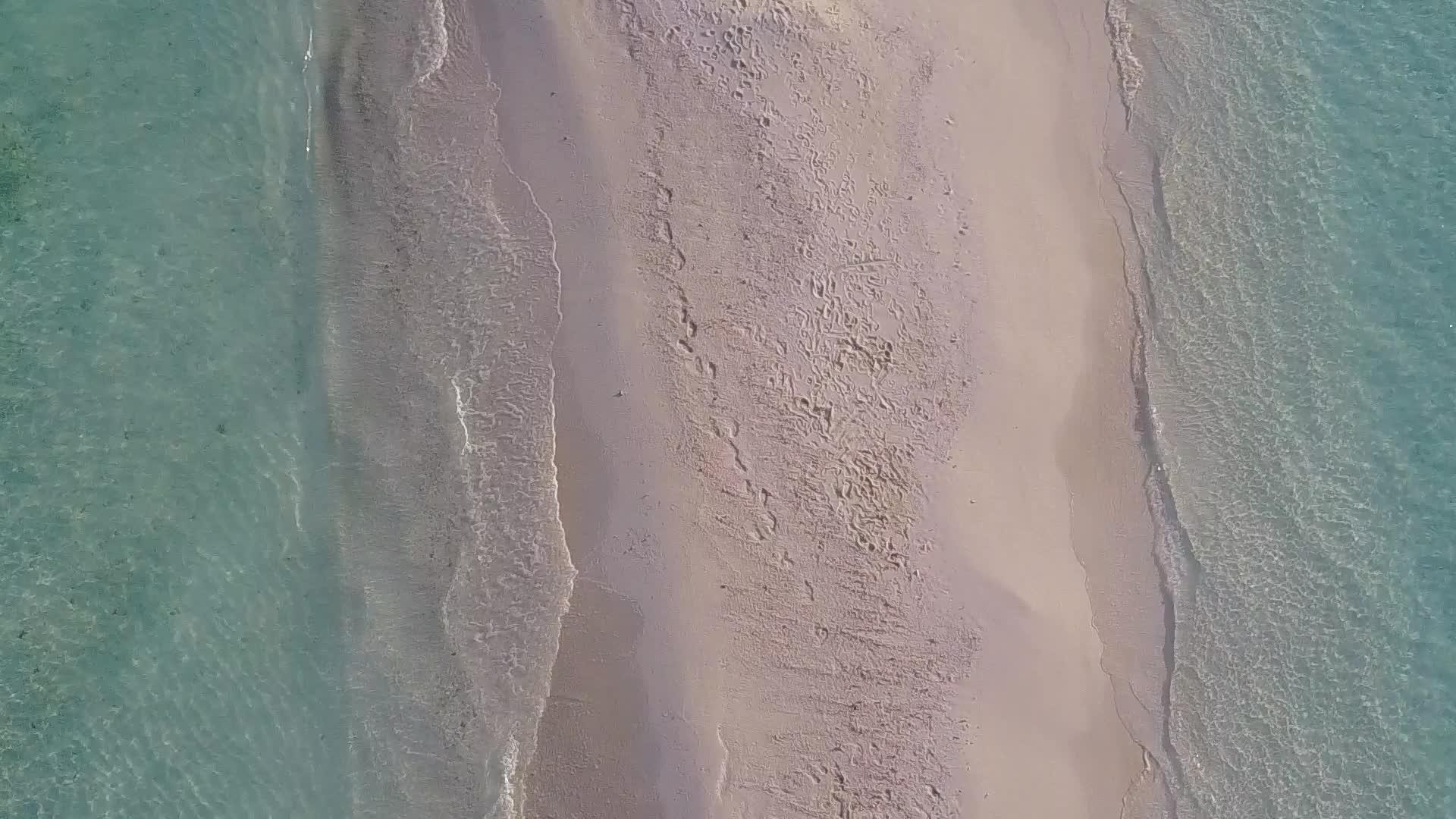 在蓝色的水和白色的海滩背景下空中无人驾驶飞机面对美丽的海岸视频的预览图