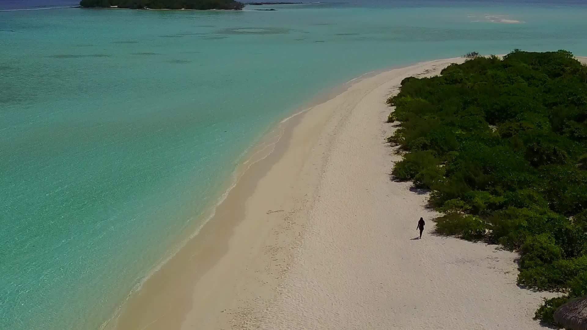 蓝色海洋和白色海滩的背景被暗礁湖海滩周围的空中观景所打断视频的预览图