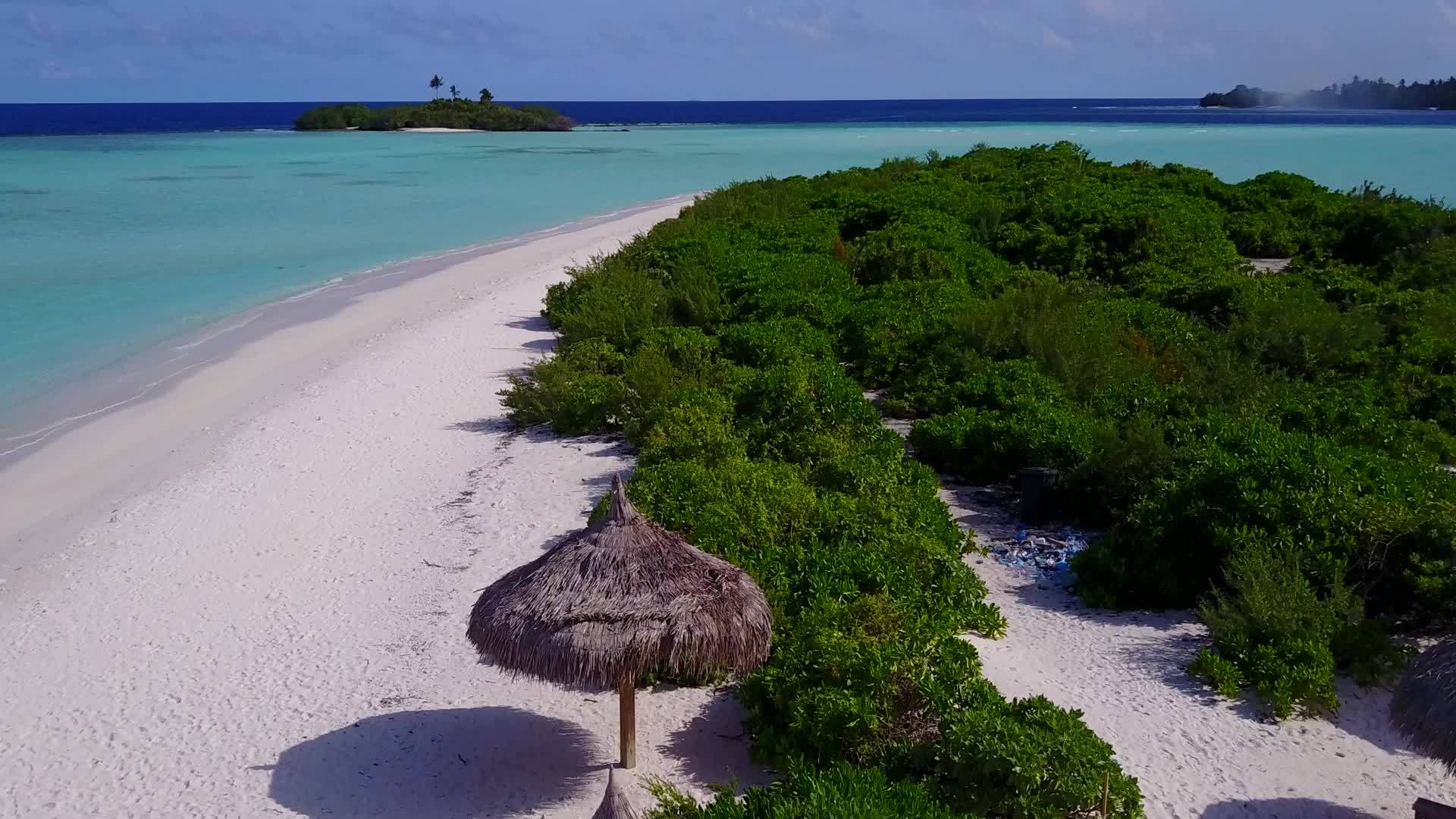 空中无人驾驶以绿色海洋和白沙为背景放松海岸海滩之旅视频的预览图