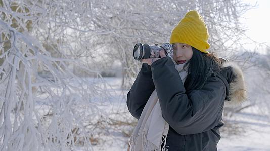 4k女性摄影师雪景雾凇旅行拍照视频的预览图
