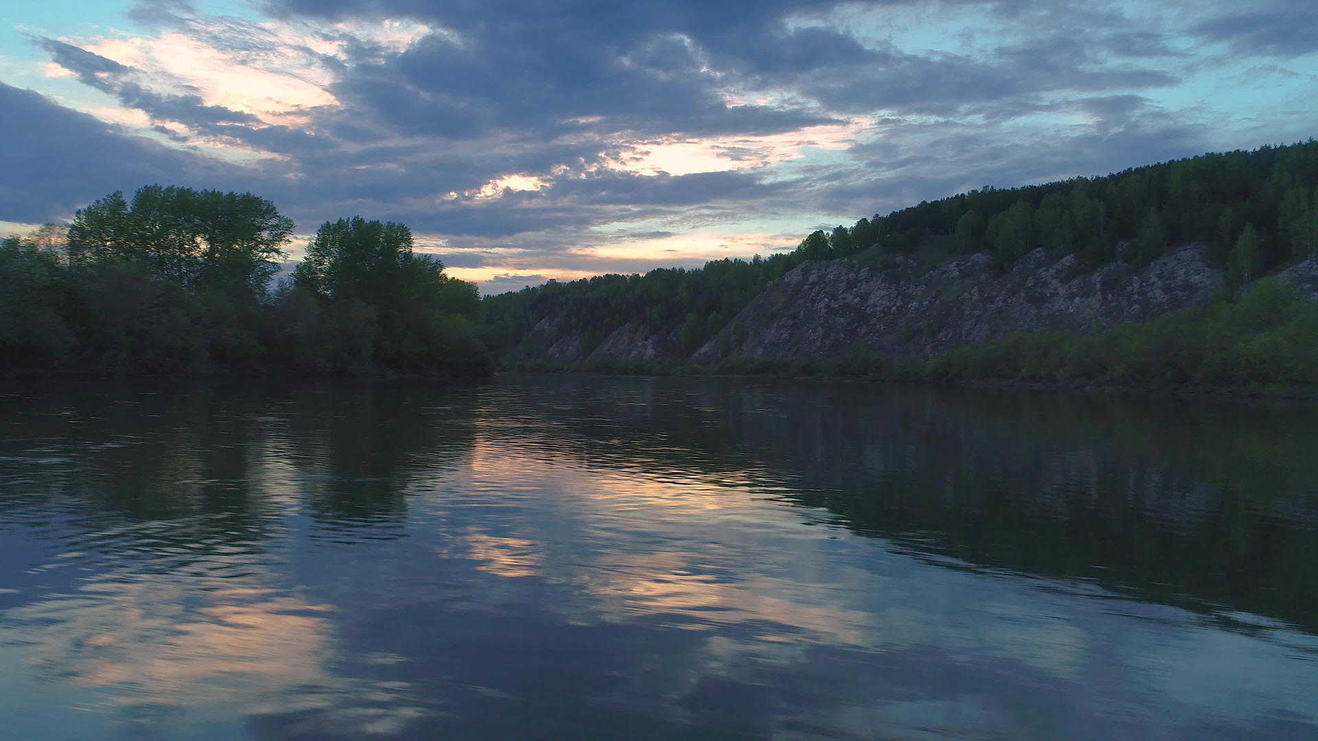 日落时飞到河对岸的右边河边有许多岩石和岩石视频的预览图