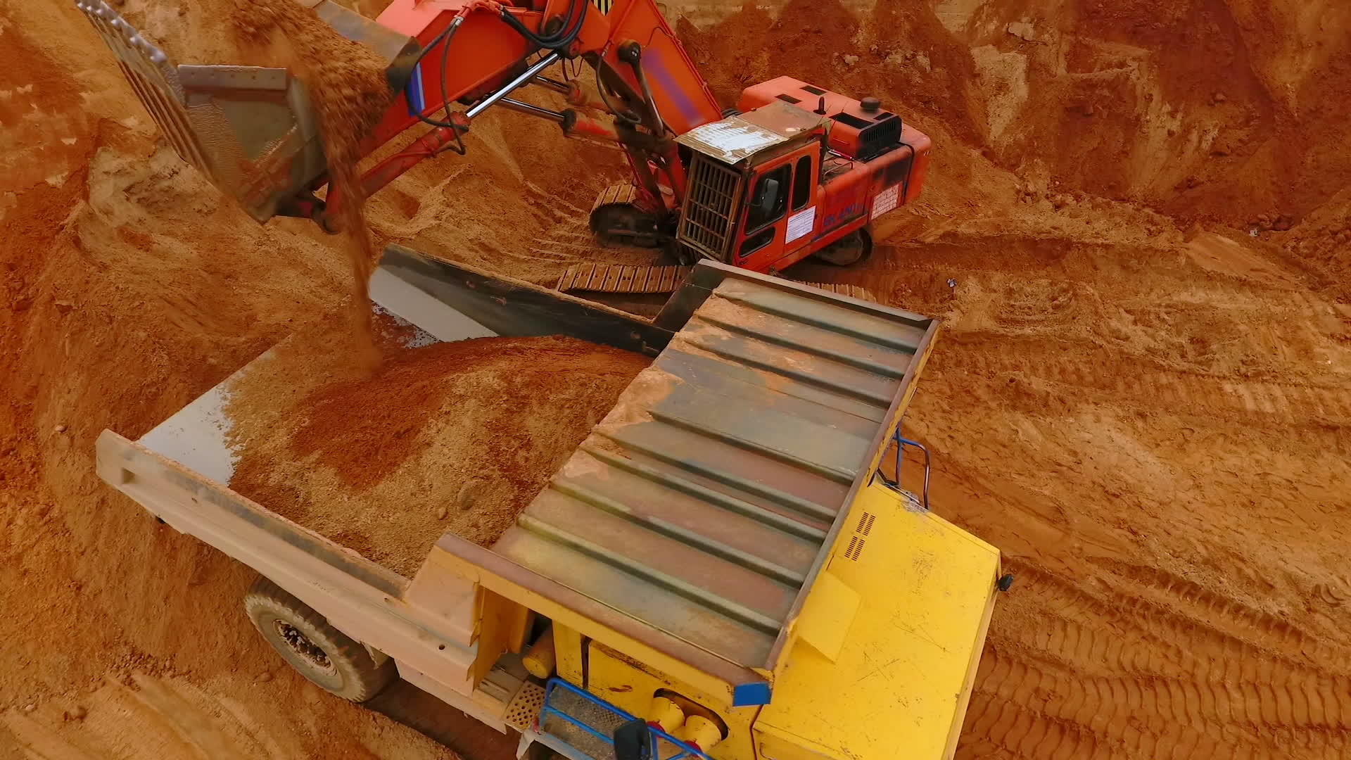 采矿挖掘机将沙子装入砂石场的垃圾卡车中视频的预览图