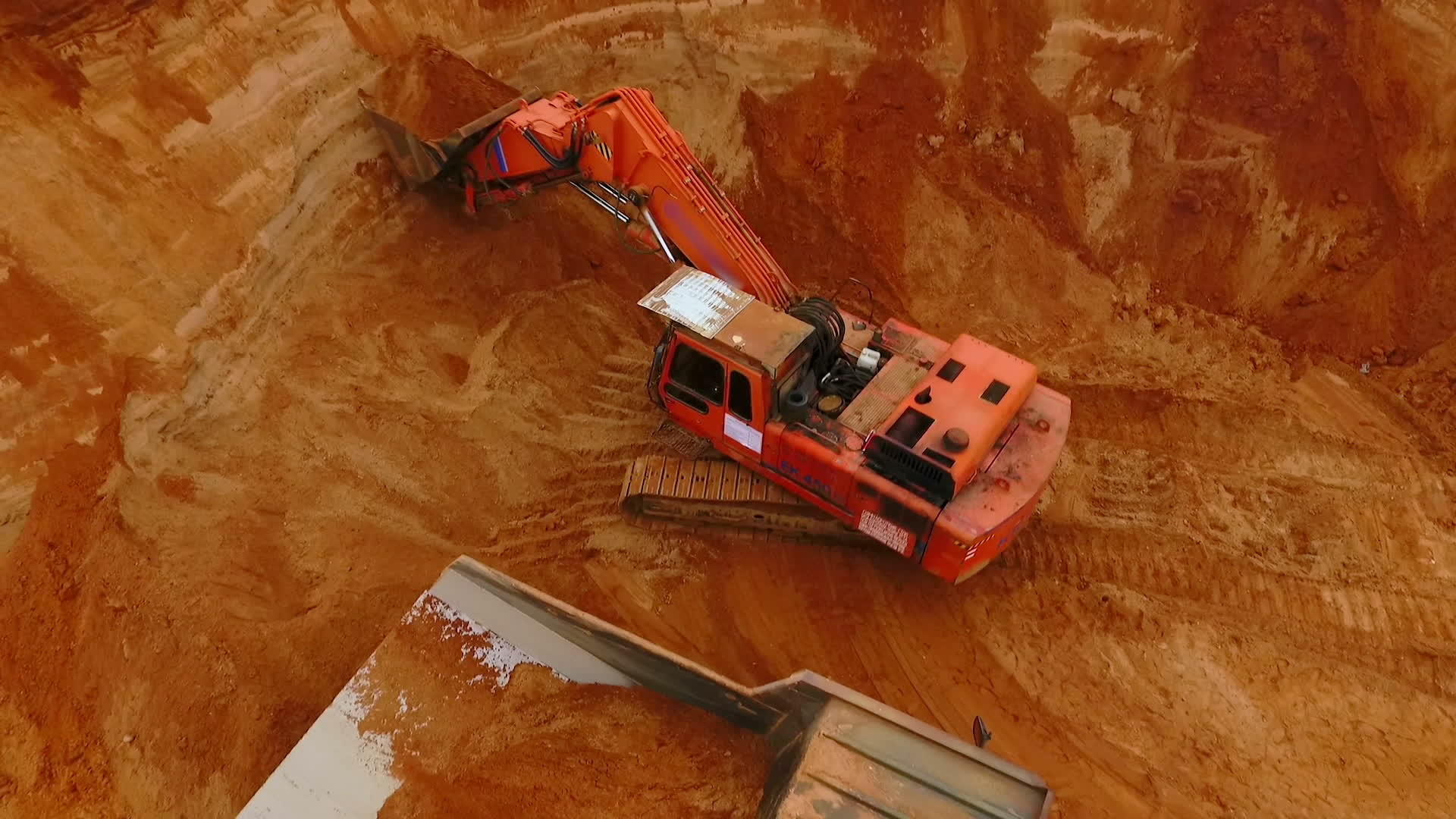 从上面看采矿挖掘机倾倒卡车上的沙子视频的预览图