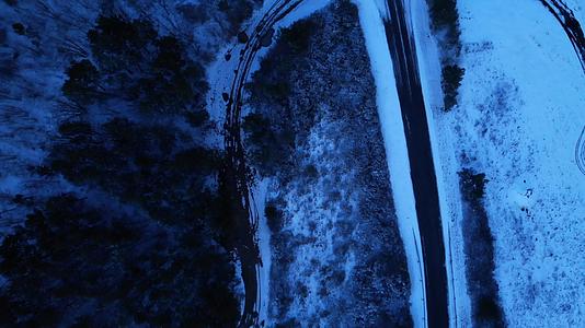 自然蓝色的夜晚法国白雪皑皑的乡村黎明路和森林雪下的田野视频的预览图