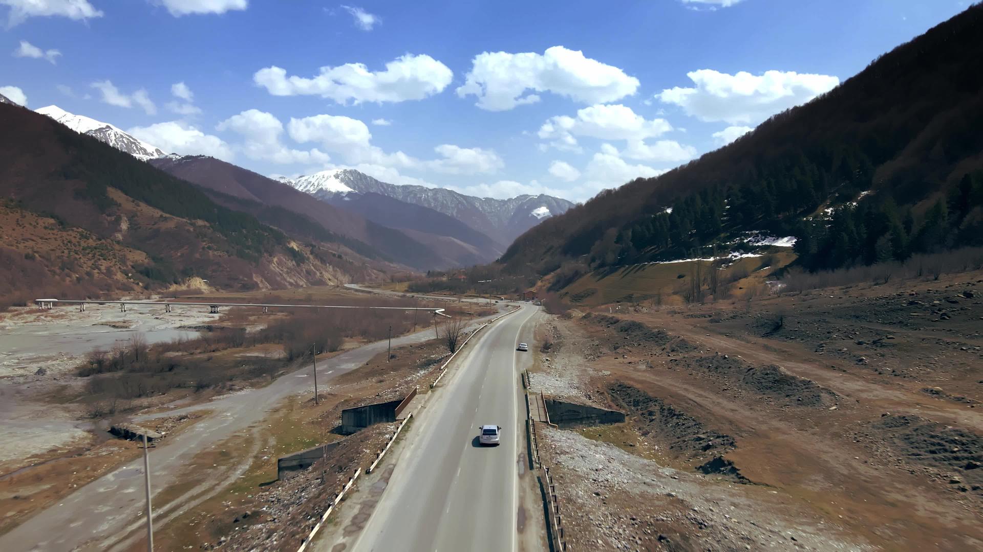 令人难以置信的是无人驾驶飞机沿着汽车驶往峡谷的高速公路视频的预览图