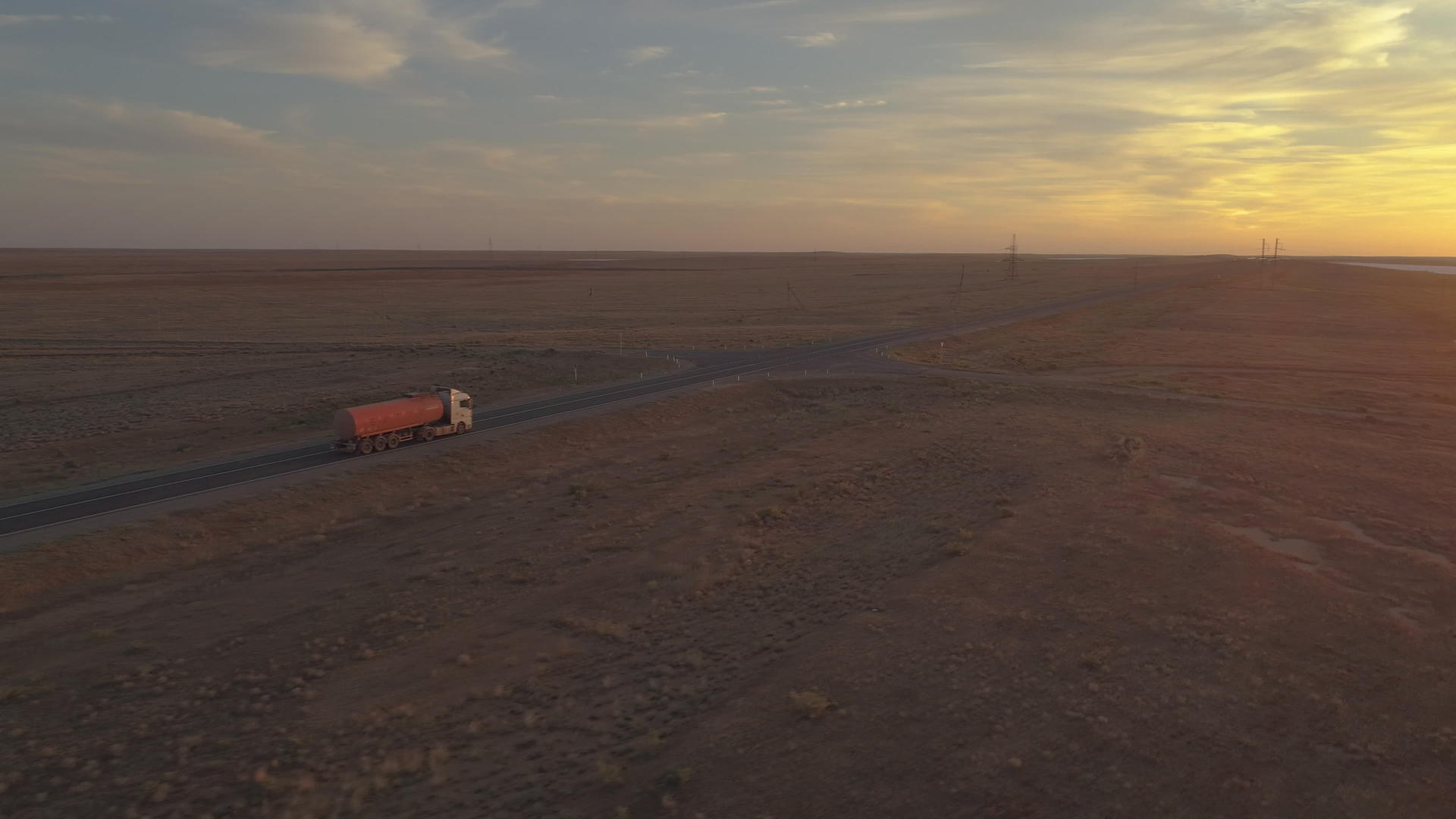 日落时卡车驶往高速公路空中观光视频的预览图