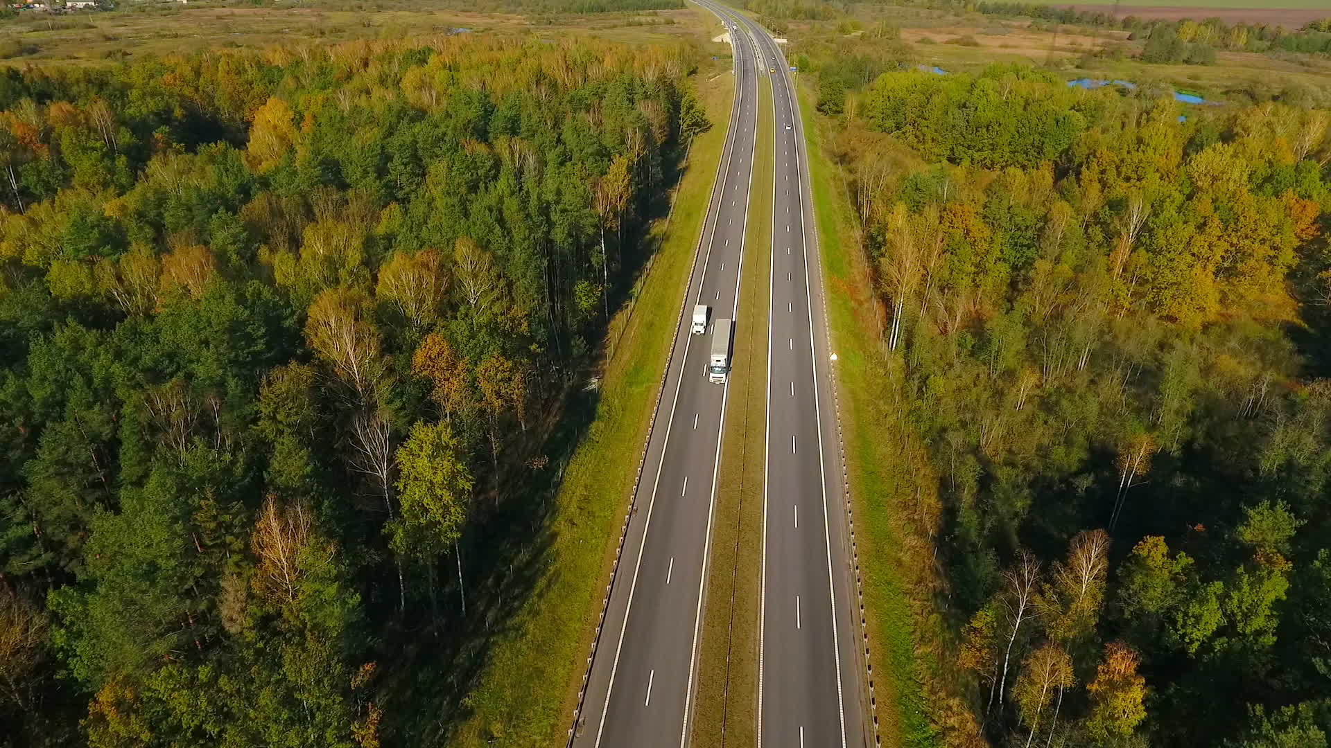 在空中观察公路上的森林地貌视频的预览图