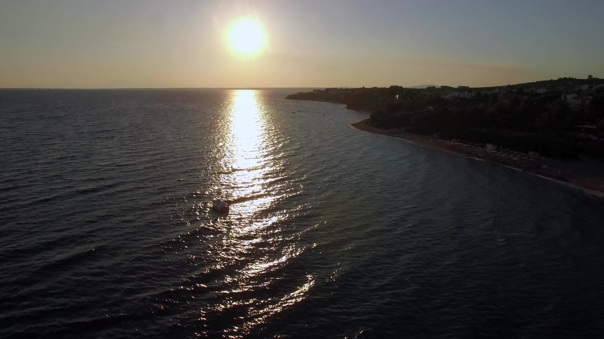 日落时船只在海岸和海面上飞行视频的预览图