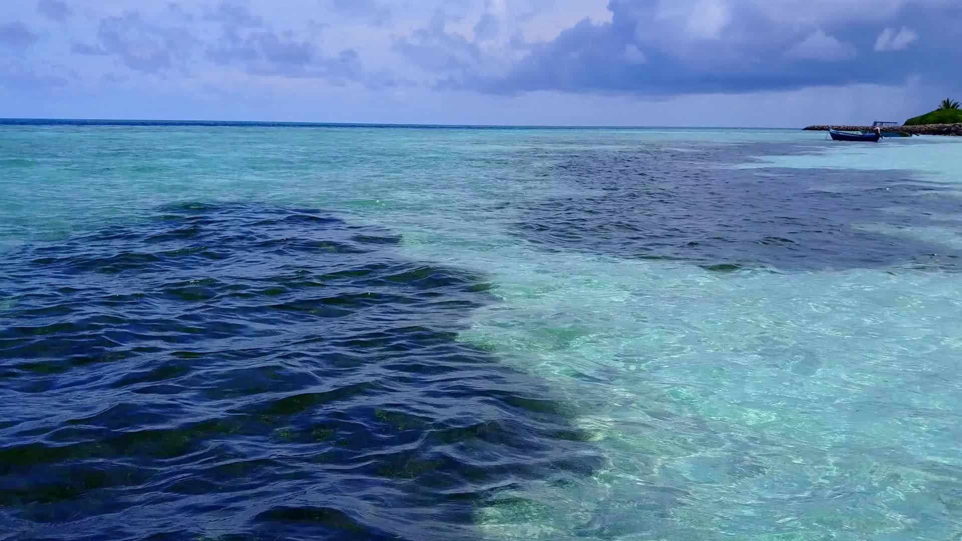 在蓝色的水和明亮的沙滩背景下田园诗般的海岸海滩时间视频的预览图