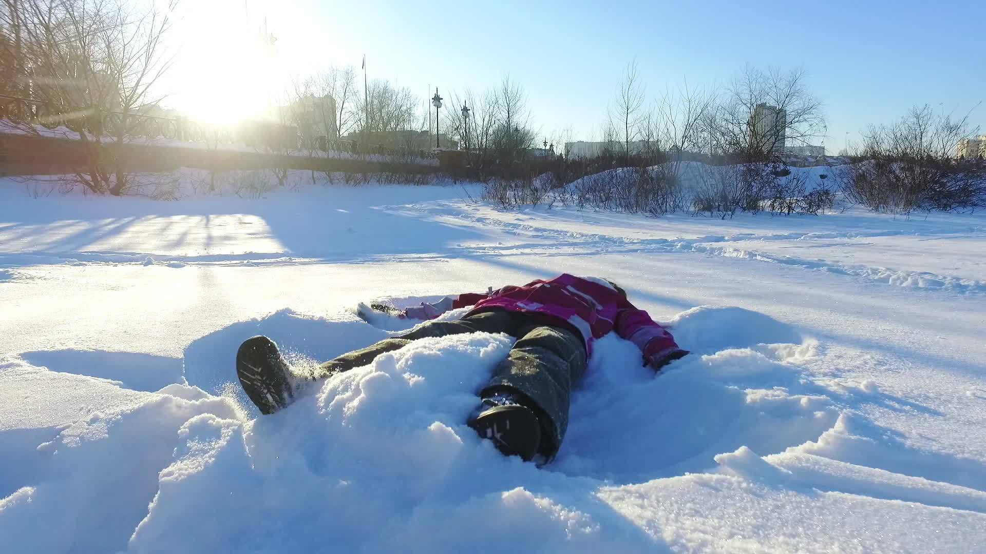 小女孩做雪天使冬季假日视频的预览图
