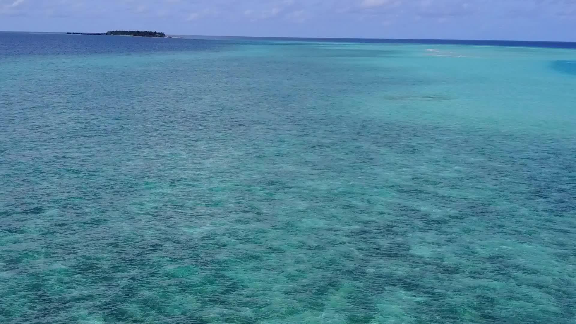 在蓝绿色泻湖和白沙的背景下无人机放松了海景海滩的生活方式视频的预览图