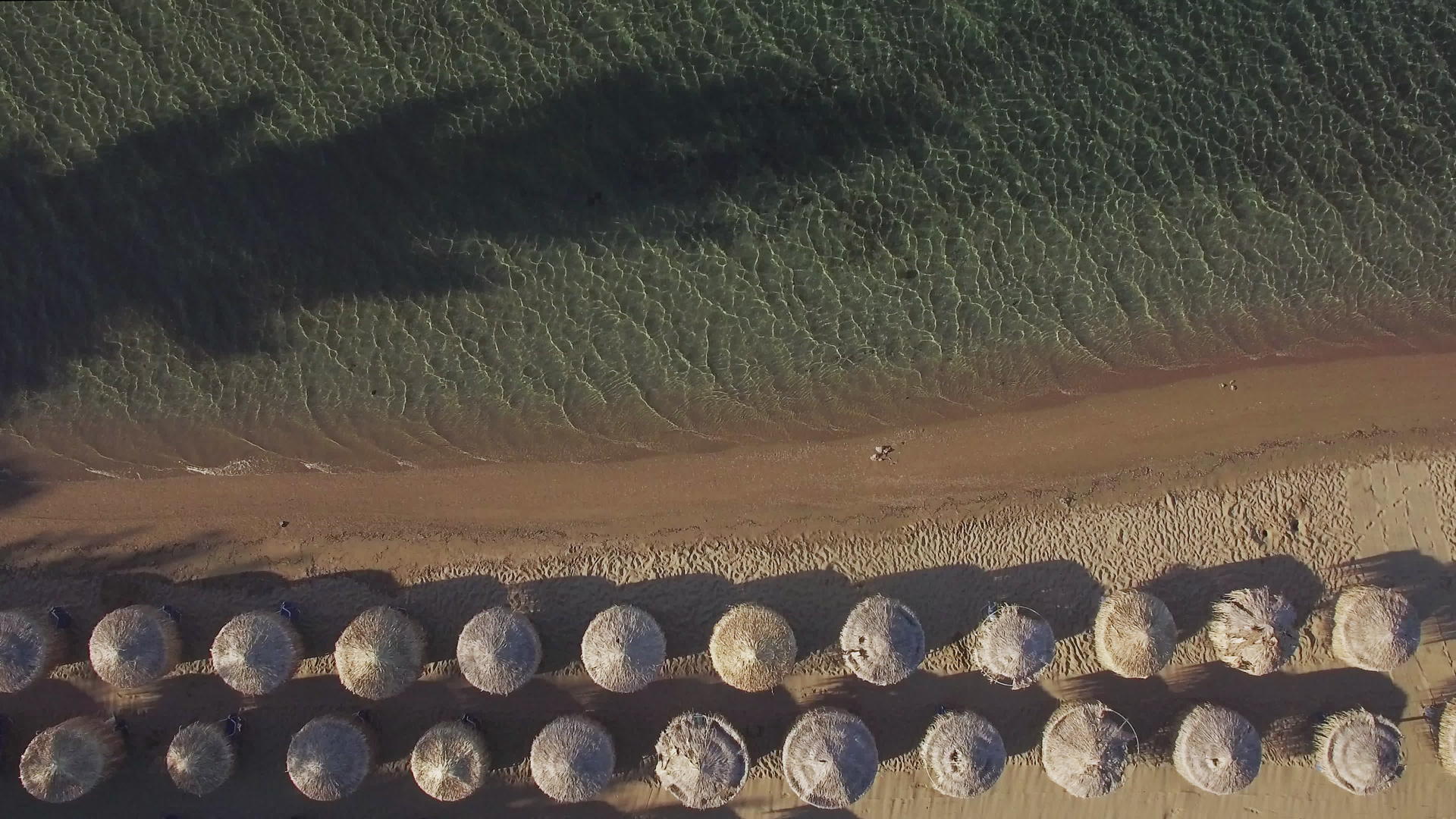 海和沙滩海岸有草伞和草伞视频的预览图