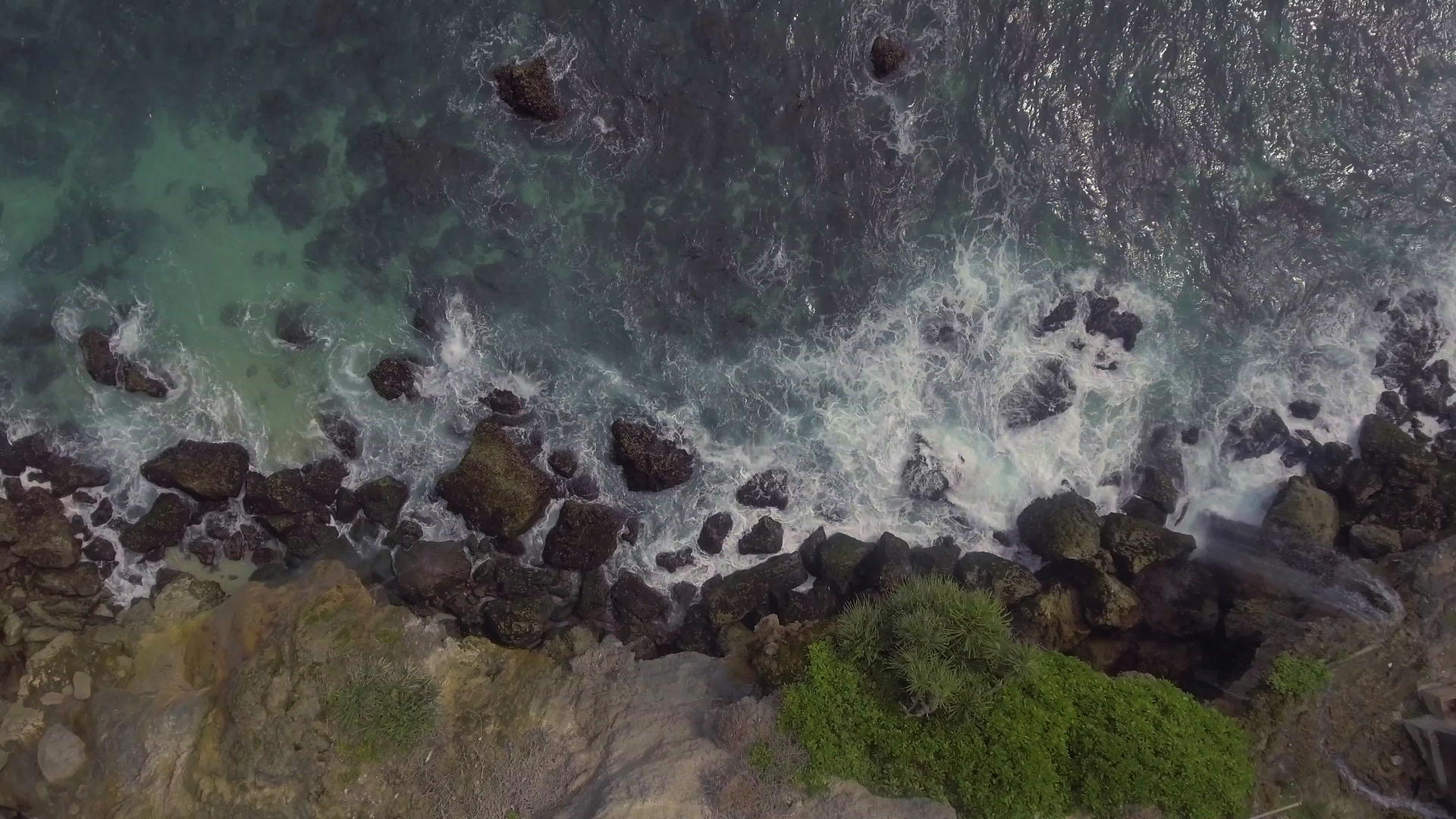 波吉扬安瀑布顶部环绕岩石海岸的海浪碰撞背景视频的预览图