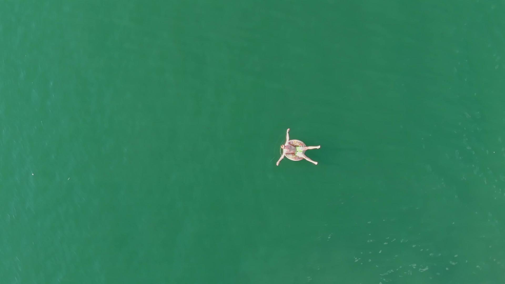 从上到下我看到一个人喜欢在湖中央一个充气的游泳圈视频的预览图