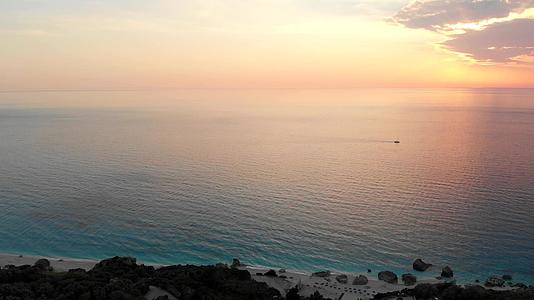 美丽、平静和丰富多彩的日落在海洋上有一个船轮的背景在空中观察视频的预览图