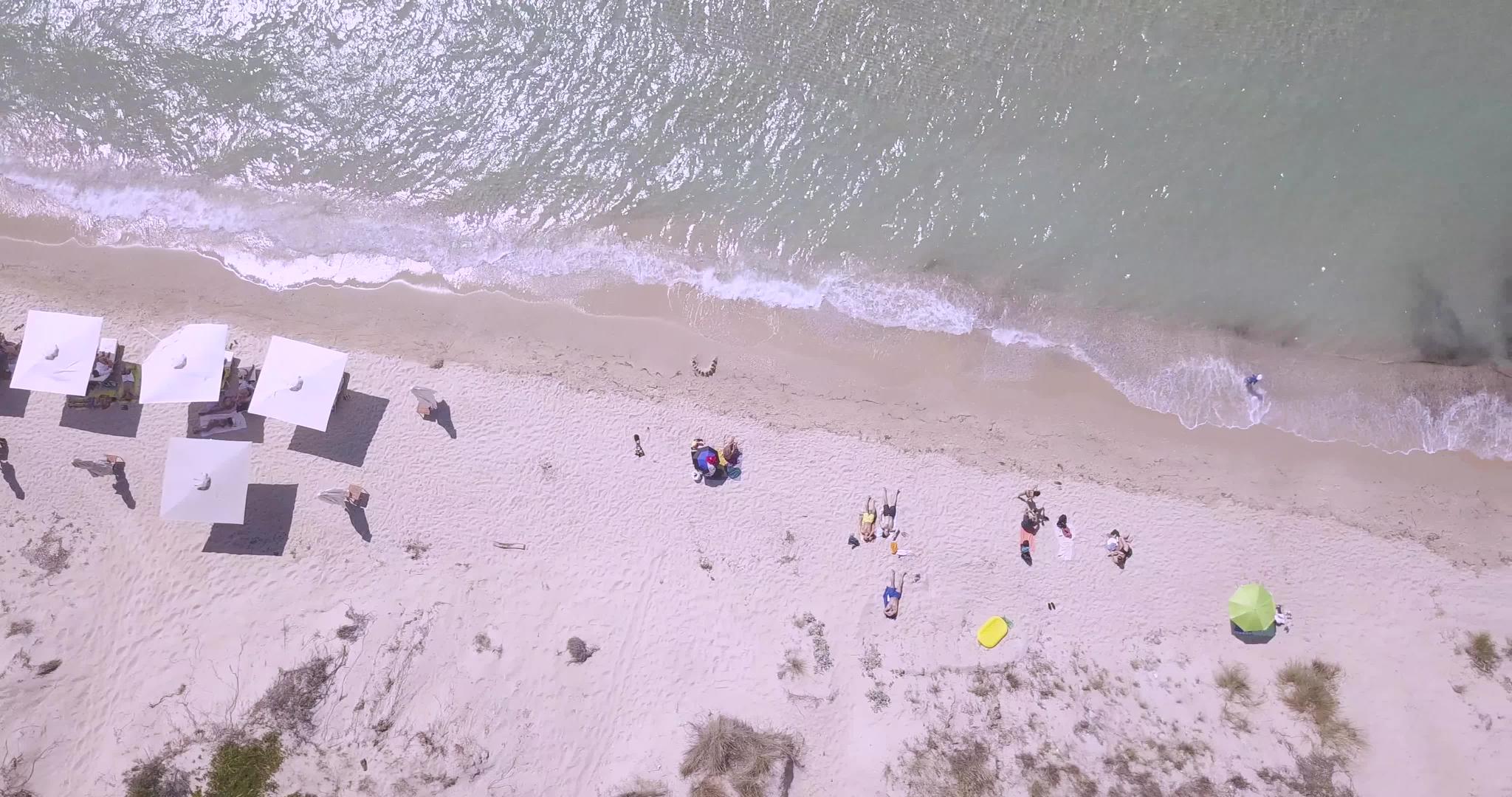 雨伞和人们日光浴的热带海滩风景视频的预览图