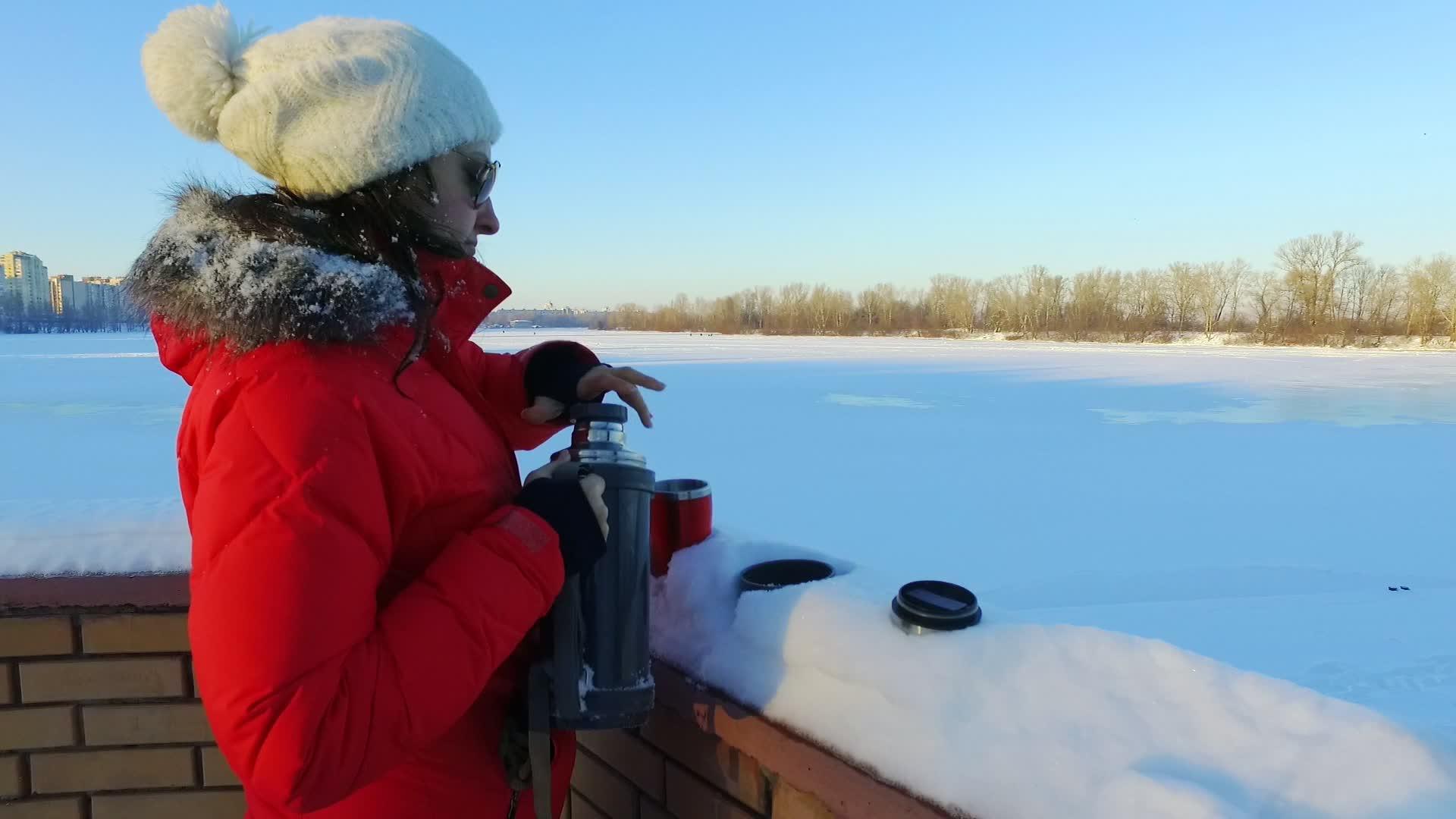 冬季公园的年轻女性喝茶或咖啡视频的预览图