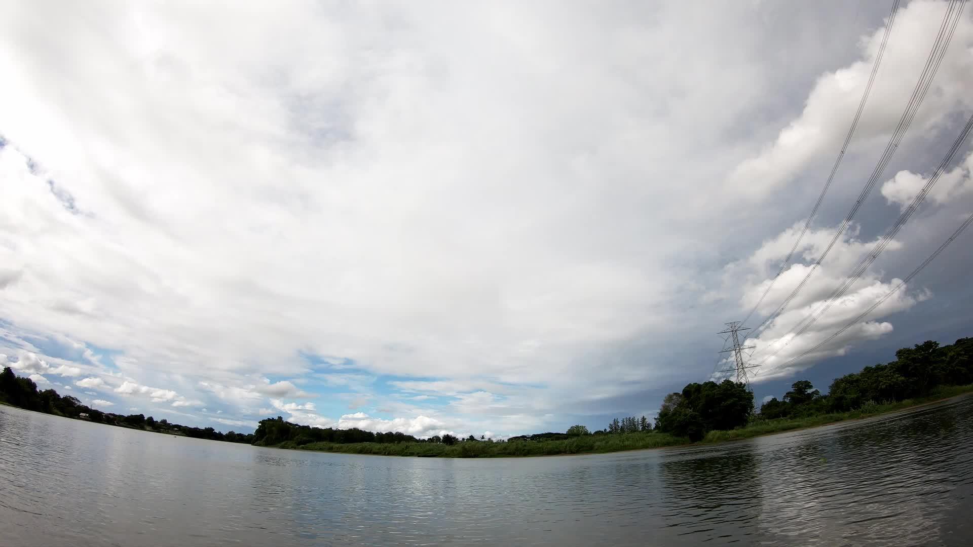 高压电线杆在河上倾斜白天黎明时云层迅速移动视频的预览图