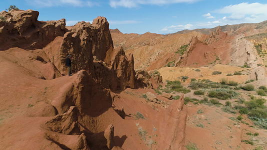 游客在阳光明媚的日子拍摄红色峡谷和蓝天鸟瞰图周围环绕着无人机视频的预览图