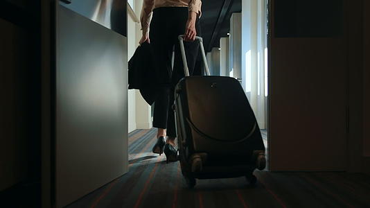 酒店走廊里有行李箱的女商人视频的预览图