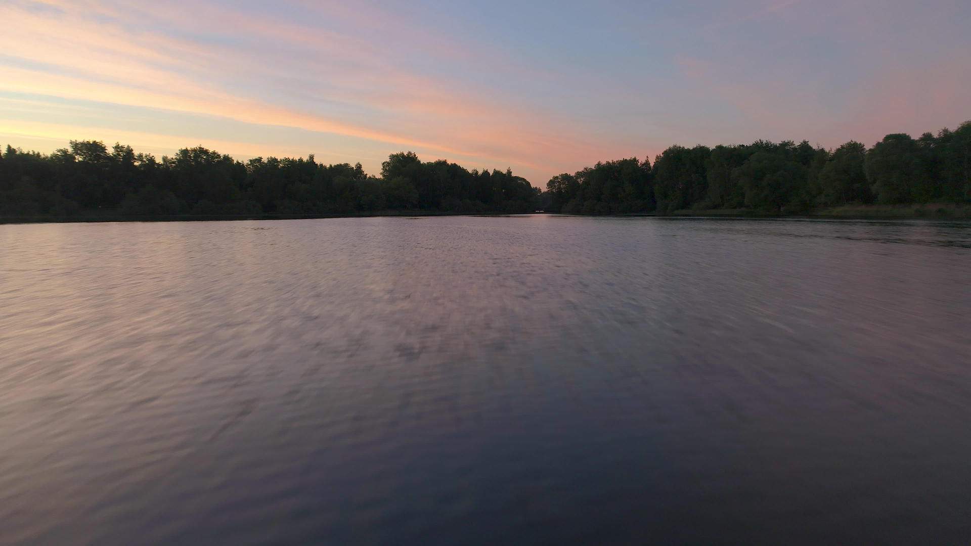在一个阳光明媚的早晨以低角度快速飞越湖面视频的预览图