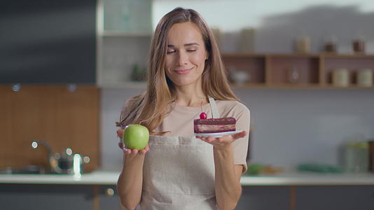 家庭生活减肥女性选择蛋糕或苹果视频的预览图