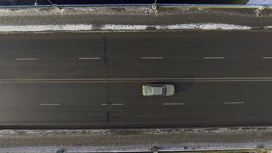 两辆车在两条公路上穿过雪地的空中行驶视频的预览图