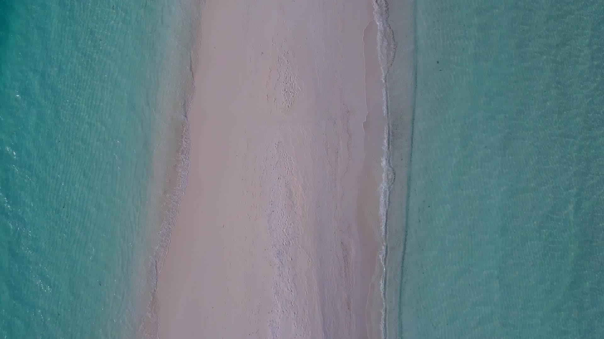 美丽的旅游海滩被白色沙滩底部的绿色大海打破空中无人驾驶视频的预览图