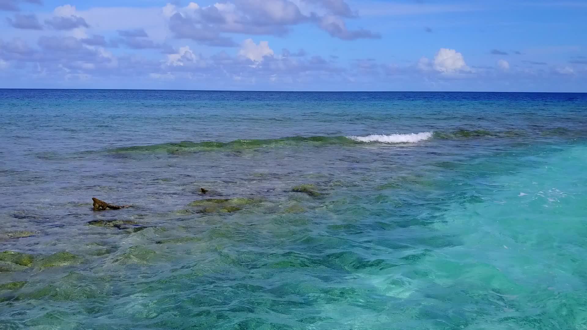 蓝绿色海洋度假胜地以蓝天、绿海和白沙为背景视频的预览图