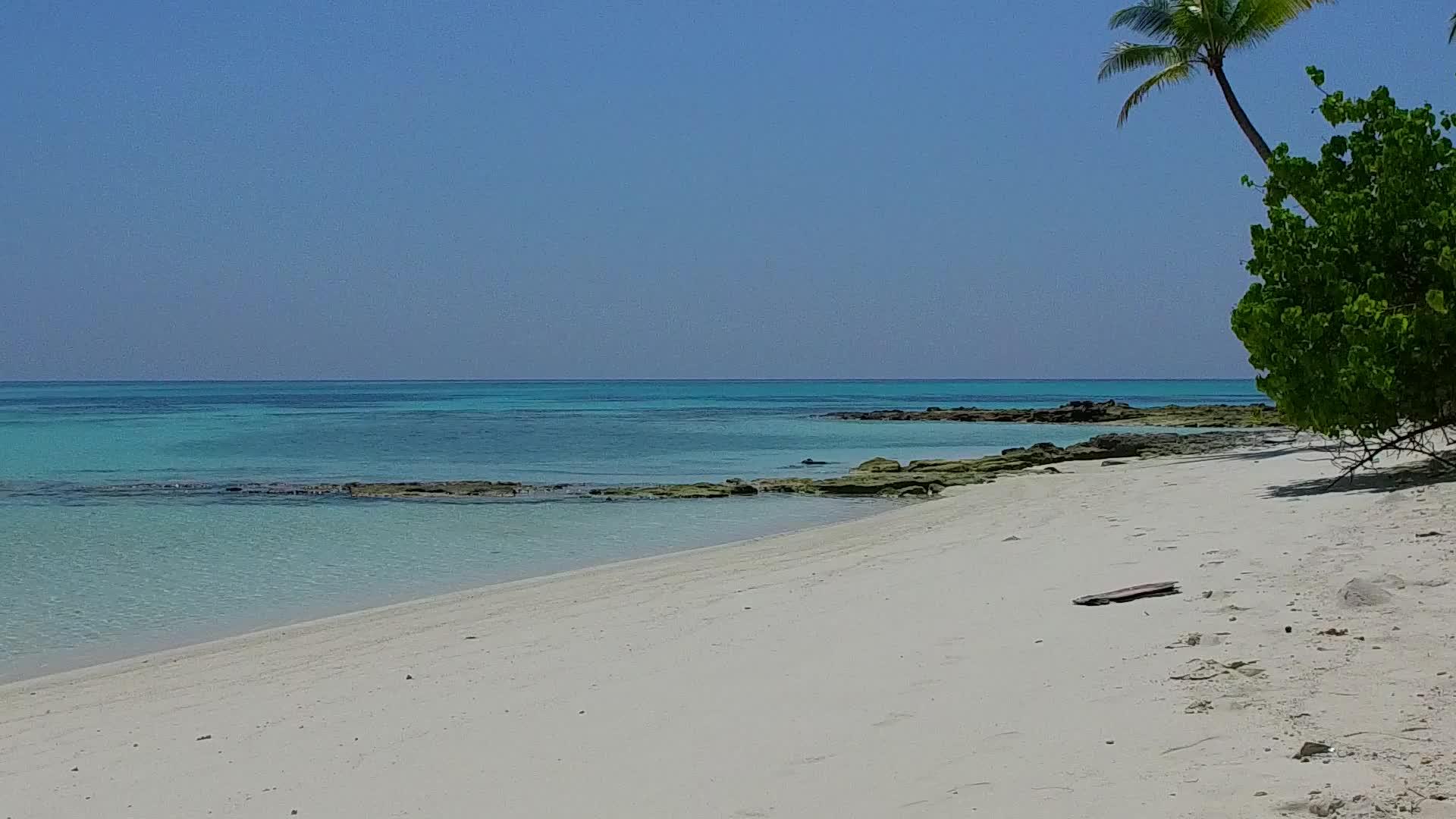 蓝绿色海洋度假胜地以蓝天、绿海和白沙为背景视频的预览图