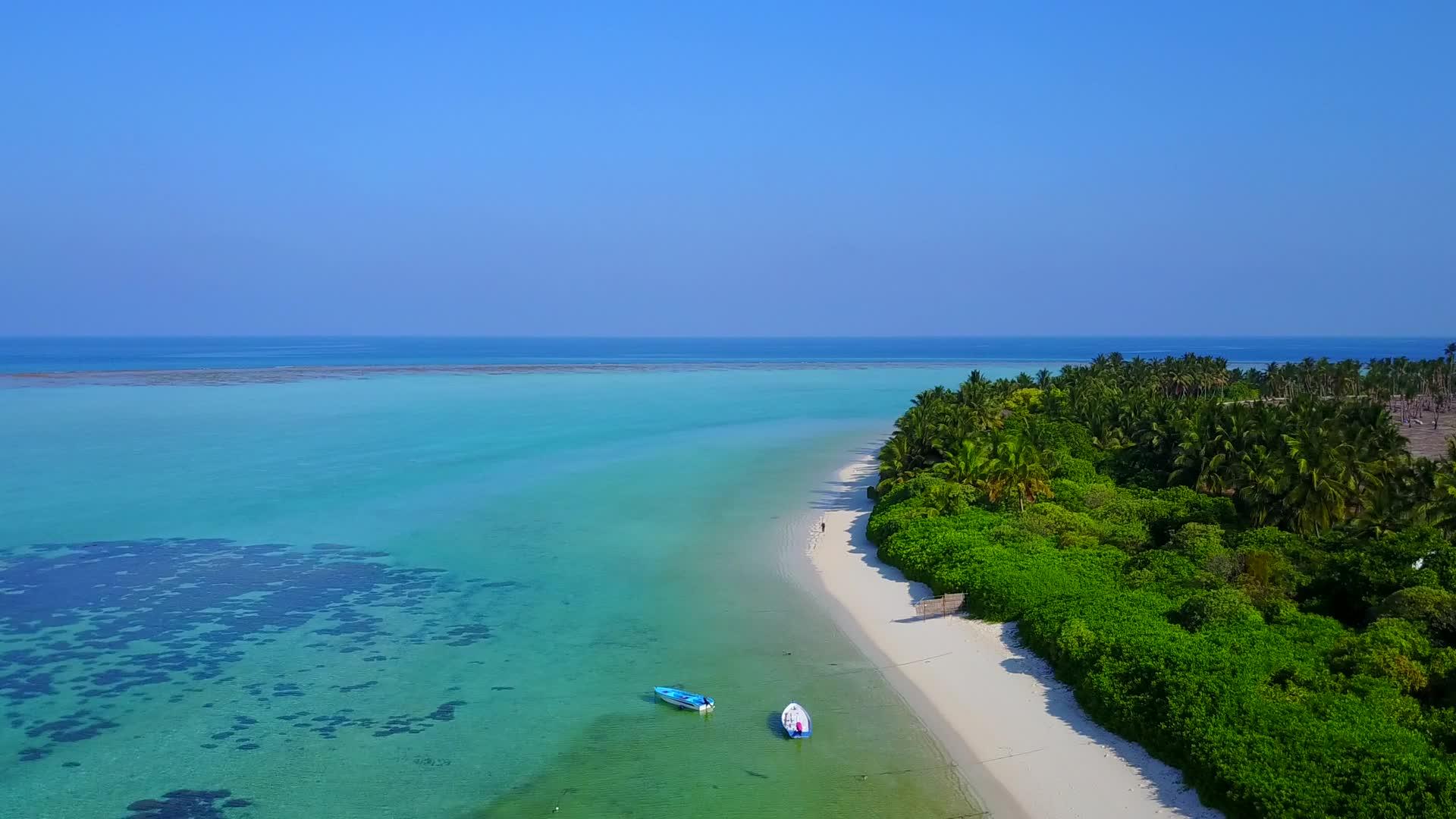 以蓝色水和白色沙滩为背景的美丽海岸海滩之路在天空中视频的预览图