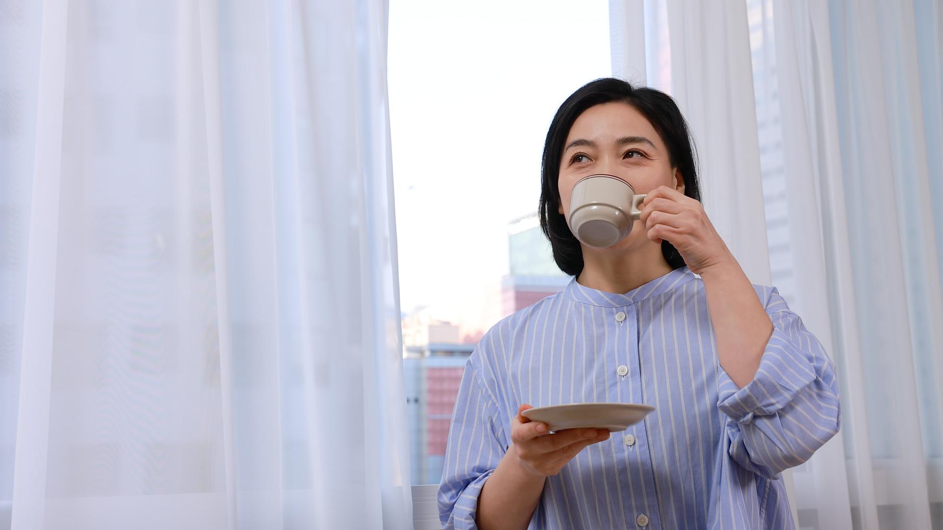短发中年女性窗前喝咖啡视频的预览图