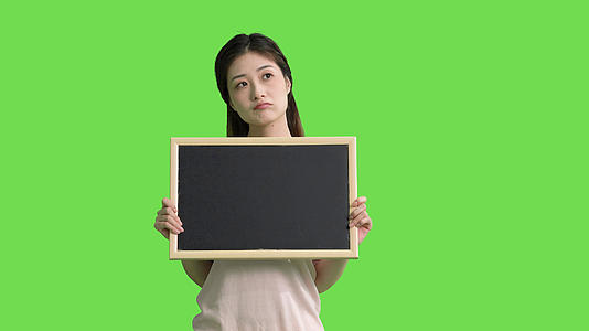 4k手拿黑板的女生思考表情动作绿幕抠像视频视频的预览图