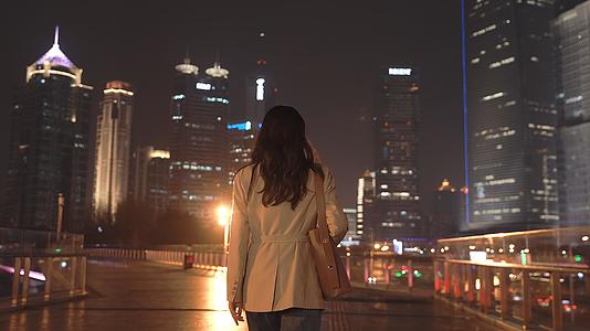 4K户外秋冬夜晚散步的女性背景升格100p视频的预览图