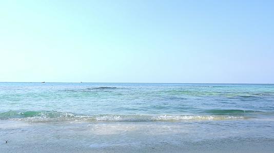 早晨海滩上的涟漪与蓝色和粉色的天空相映成趣视频的预览图