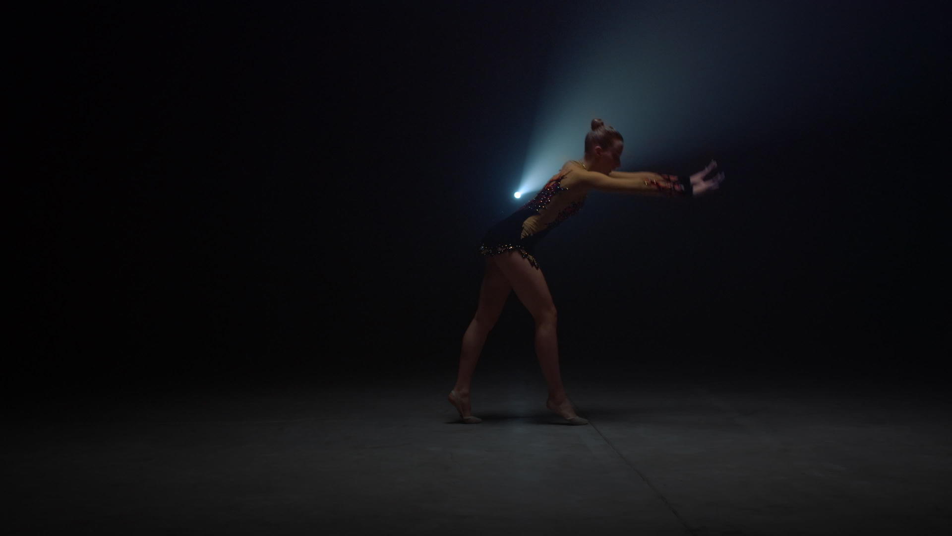 在黑暗的舞蹈室里做倒立的运动女性视频的预览图