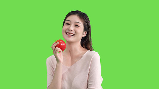 4k手拿苹果的女生绿幕抠像视频视频的预览图