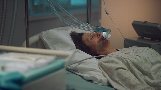 患者戴着氧气面罩躺在空荡荡的医院病房里视频的预览图