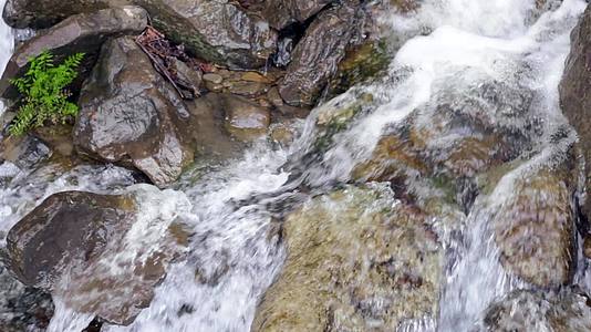 石头上的水滴落在岩石上的石头之间流动的水视频的预览图